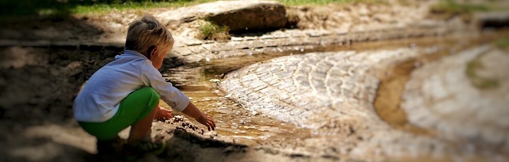 Kind am Wasserspielplatz