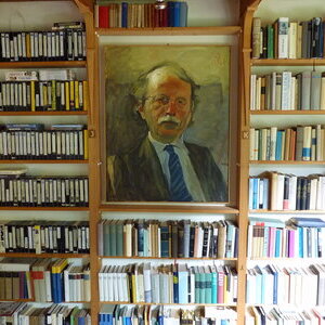 Ein Porträt des Schriftstellers Walter Kempowski inmitten eines Bücherregals im Haus Kreienhoop.